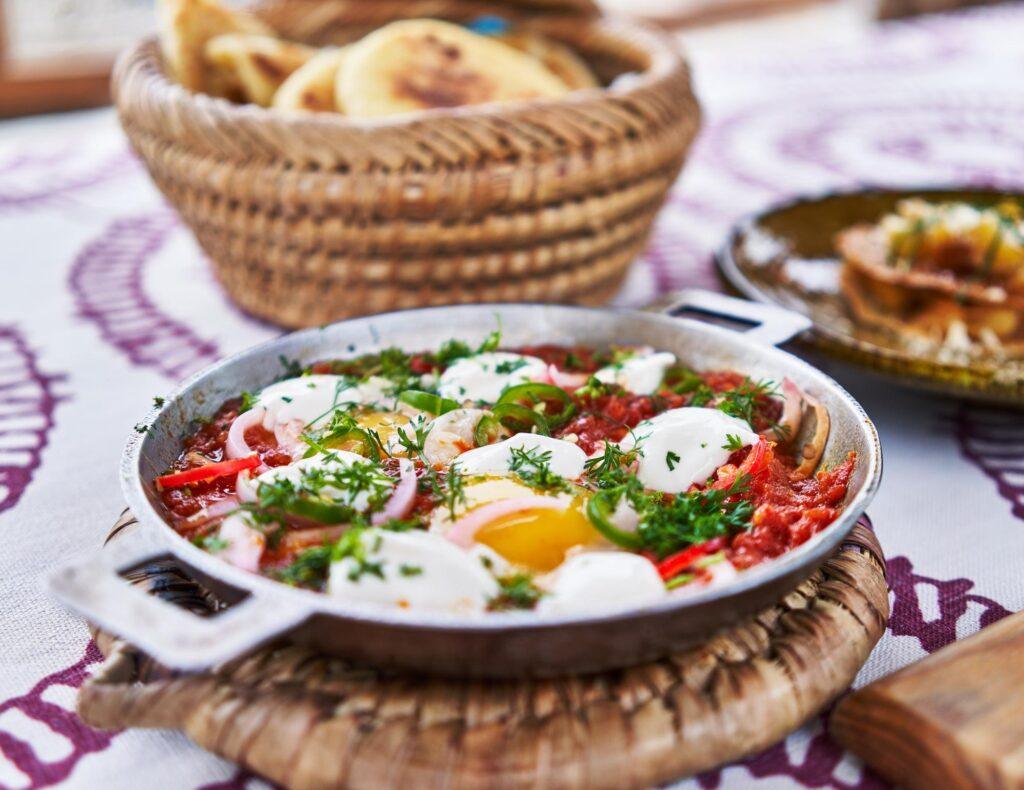 Traditional foods of Tunisia-A fresh, traditional shakshuka dish with tomatoes, eggs, and herbs in a skillet, ready for breakfast-My Travel Monkey