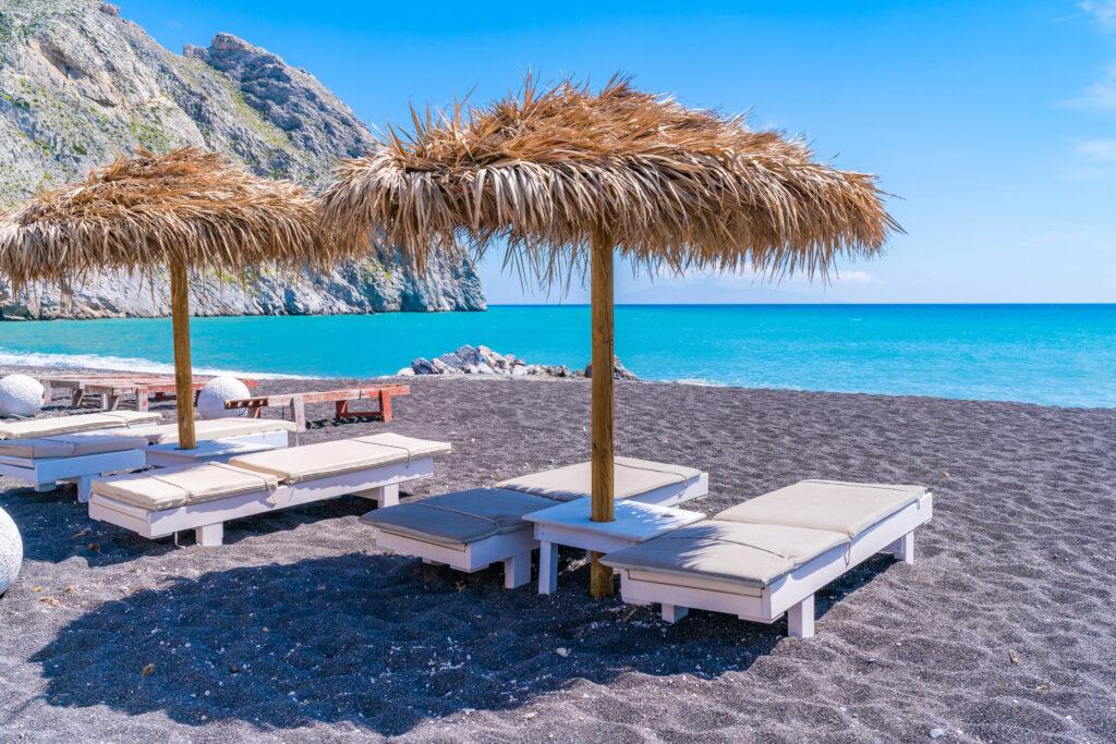Sunbeds on black sand beach Perissa-Santorini-My Travel Monkey