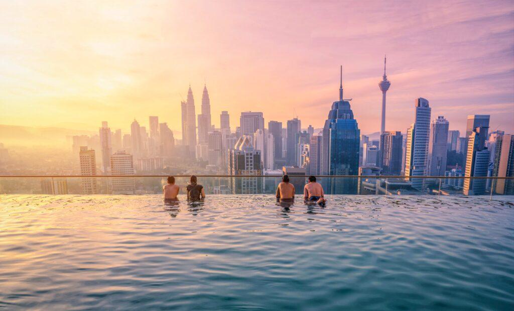 Travellers looking view skyline Kuala Lumpur city in swimming pool - My Travel Monkey